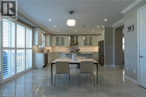 Polished tile flooring, white shaker cabinetry, stainless steel appliances, kitchen island with countertop, and recessed lighting - 455 Equestrian Way, Cambridge, ON 