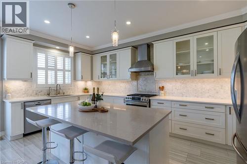 Kitchen featuring a center island, white cabinetry, integrated stainless steel appliances, a tiled backsplash, and recessed lighting - 455 Equestrian Way, Cambridge, ON 