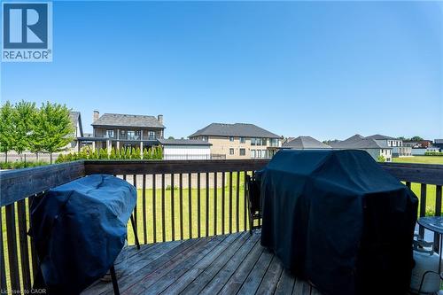 Wood deck with dark-stained railing, overlooking a level grassy expanse - 455 Equestrian Way, Cambridge, ON 