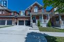 Brick facade with stone accents, covered front porch, concrete driveway, attached garage, and manicured front lawn - 455 Equestrian Way, Cambridge, ON 