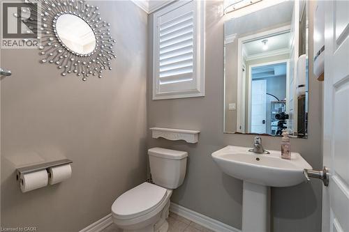 Pedestal sink with chrome faucet, toilet with decorative shelf, and window with plantation shutters - 455 Equestrian Way, Cambridge, ON 