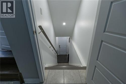 Staircase featuring a metal handrail, recessed lighting, and tile flooring - 455 Equestrian Way, Cambridge, ON 
