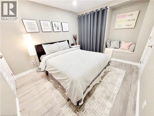 Wood-finish flooring, recessed wall niche, built-in window seating, and a large window with privacy drapery - 455 Equestrian Way, Cambridge, ON 