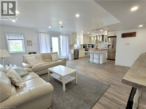 Recessed lighting, wood-finish flooring, white cabinetry, stainless steel appliances, and a kitchen island with seating - 455 Equestrian Way, Cambridge, ON 