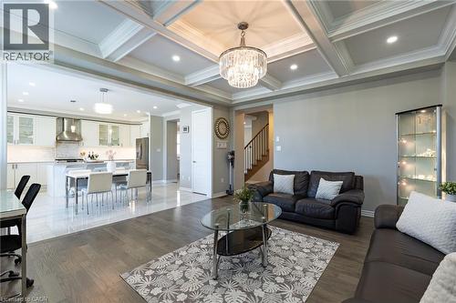 Coffered ceiling with a crystal chandelier, recessed lighting, and wood-finish flooring - 455 Equestrian Way, Cambridge, ON 