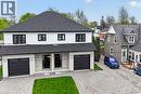 Modern duplex featuring dual black garage doors and white brick facade - 45A Howard Street, Hagersville, ON 