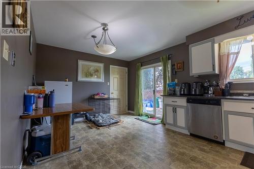 Kitchen with light-toned floor tiles, white and gray cabinetry, dark countertops, and a stainless steel dishwasher - 120 Union Street S, Cambridge, ON 