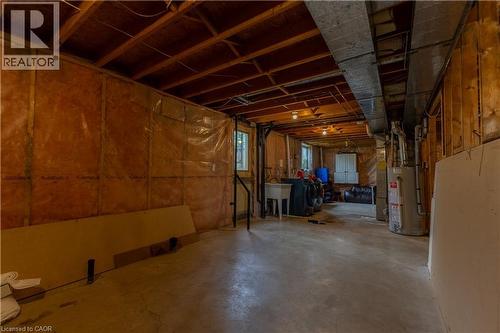 Unfinished basement space with exposed wood joists, concrete flooring, utility sink, and visible ductwork - 120 Union Street S, Cambridge, ON 