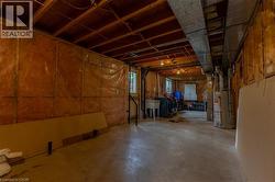 Unfinished basement space with exposed wood joists, concrete flooring, utility sink, and visible ductwork - 