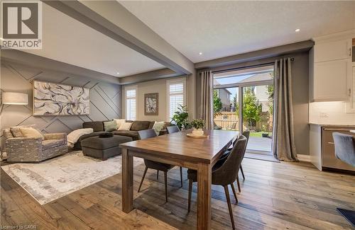 Open-concept living space featuring wood-finish flooring, recessed lighting, and a decorative accent wall - 35 Greyhawk Street, Kitchener, ON 