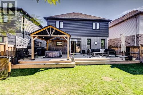 Expansive backyard featuring a manicured lawn, a multi-level deck, a wooden pergola, and a private fenced perimeter - 35 Greyhawk Street, Kitchener, ON 