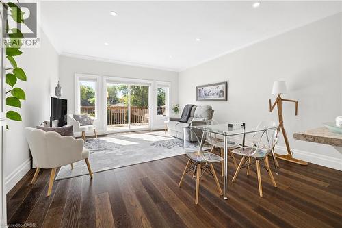 Dark wood-finish flooring, white painted walls, recessed ceiling lighting, crown molding, and sliding glass doors to outdoor decking - 192 Brewery Street Unit# 18, Baden, ON 