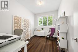 Wood-finish flooring with white baseboards, a single window with white blinds, and a white ceiling light fixture - 