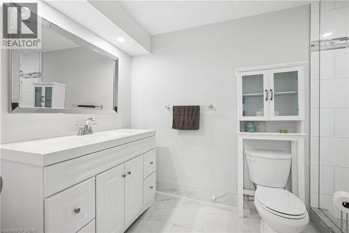 White vanity with integrated sink, rectangular framed mirror, recessed lighting, and over-toilet storage cabinet - 192 Brewery Street Unit# 18, Baden, ON 