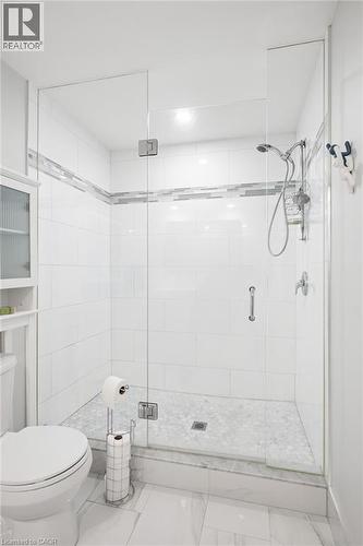 Glass-enclosed shower with a tiled surround, integrated grab bar, and a handheld shower fixture - 192 Brewery Street Unit# 18, Baden, ON 