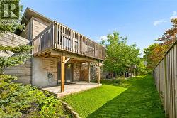 Elevated wood deck with railing, ground-level wood patio, brick exterior, - 