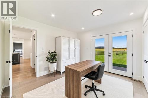 French doors with exterior scenery, wood-finish flooring, white built-in cabinetry, recessed lighting, and a flush mount light fixture - 5367 2 Side Road, Milton, ON 