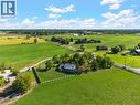 Expansive property featuring a two-story residence with a red brick facade, surrounded by a large green lawn and mature trees - 5367 2 Side Road, Milton, ON 
