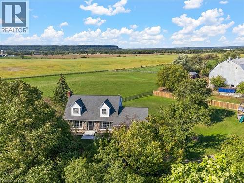 Stone-clad residence featuring a dormer roof and a prominent chimney - 5367 2 Side Road, Milton, ON 