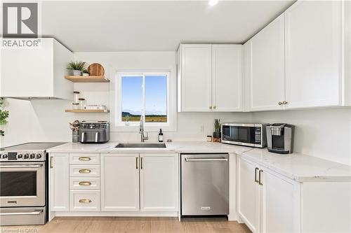 White shaker cabinetry, light-toned wood-finish flooring, stainless steel appliances, a stainless steel sink, and light-toned countertops - 5367 2 Side Road, Milton, ON 