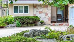 Stucco exterior with stone veneer accents, decorative front entry door, and a concrete driveway - 