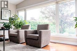 Expansive window wall with white trim, wood-finish flooring, and light-toned wall paint - 