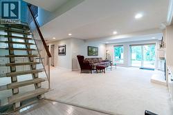 Spacious living area featuring carpet flooring, recessed lighting, and a fireplace with built-in cabinetry - 