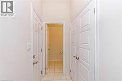 Hallway featuring white panel doors and tile flooring - 