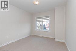 Neutral tone wall finishes, carpeting, and a window with blinds - 
