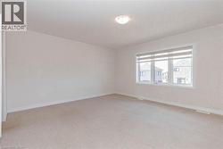 Carpeted room with a flush-mount ceiling light and a window with horizontal blinds - 