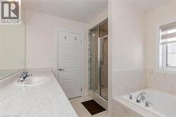 White paneled door, built-in bathtub, glass-enclosed shower, single vanity with integrated sink, and a window with blinds - 