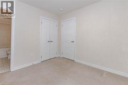 Neutral toned walls, light-colored carpeting, white paneled doors, and recessed ceiling lighting - 