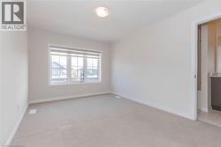 Neutral wall paint, light-toned carpet flooring, white trim, and a ceiling light fixture - 