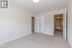 Wall-to-wall carpeting, overhead flush mount lighting, and white trim - 