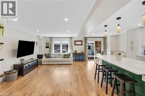 Open-concept layout featuring wood-finish flooring, recessed lighting, and a kitchen island with pendant lights - 311 Misty Crescent, Kitchener, ON - Indoor Photo Showing Other Room