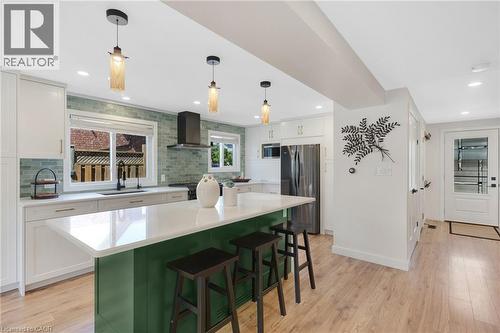 Kitchen featuring a central island with white countertop, subway tile backsplash, white cabinetry, and stainless steel appliances - 311 Misty Crescent, Kitchener, ON - Indoor Photo Showing Kitchen With Upgraded Kitchen