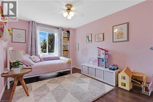 Ceiling fan with integrated lighting, built-in shelving, window with natural illumination, and wood-finish flooring - 311 Misty Crescent, Kitchener, ON - Indoor Photo Showing Bedroom