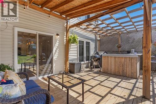 Expansive wooden deck featuring a slatted pergola, built-in wooden bar, and sliding glass patio door - 311 Misty Crescent, Kitchener, ON - Outdoor With Deck Patio Veranda With Exterior