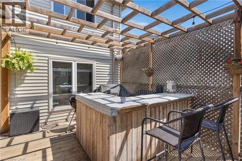 Wood deck with a pergola, featuring a built-in wood bar, privacy lattice, and light-colored siding - 311 Misty Crescent, Kitchener, ON - Outdoor With Deck Patio Veranda With Exterior