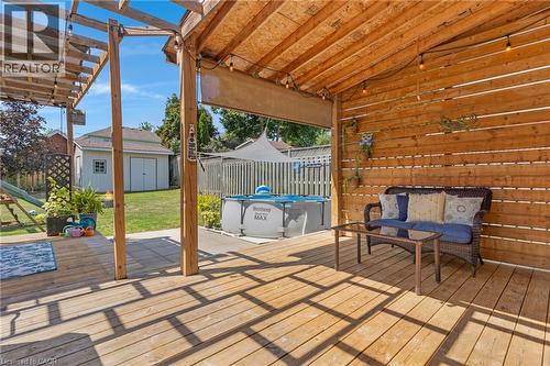 Expansive wood deck with a partial pergola cover, wood-paneled privacy wall, and string lighting - 311 Misty Crescent, Kitchener, ON - Outdoor With Above Ground Pool With Deck Patio Veranda With Exterior