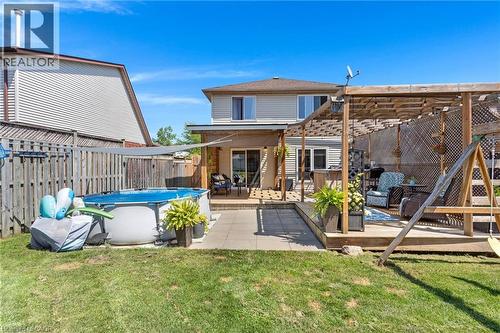 Multi-level outdoor decking and patio area with wood pergola - 311 Misty Crescent, Kitchener, ON - Outdoor With Above Ground Pool