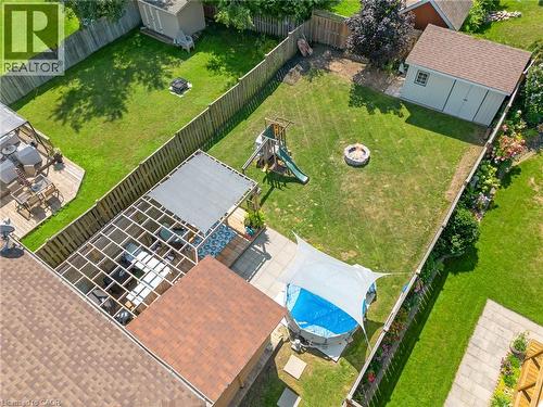 Expansive fenced yard with a wood fence, concrete patio, deck, and a detached shed - 311 Misty Crescent, Kitchener, ON - Outdoor