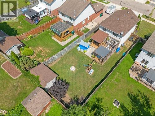 Expansive fenced backyard featuring a manicured lawn, multiple decks, and two storage sheds - 311 Misty Crescent, Kitchener, ON - Outdoor With View