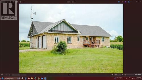Stone exterior with dual garage doors, a multi-level deck, and a shingle roof - 107 6Th Line Line, Haldimand, ON - 