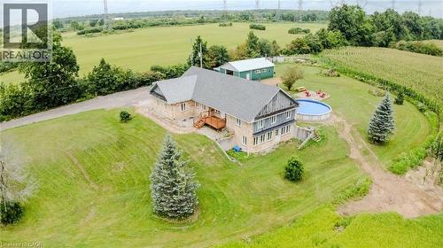 Stone and siding exterior with a multi-level deck, above-ground pool, and detached auxiliary building - 107 6Th Line Line, Haldimand, ON - Outdoor With View