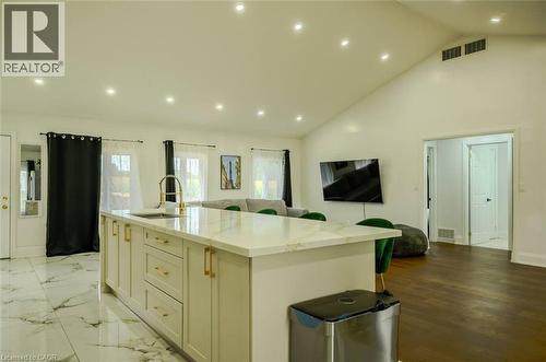 Kitchen island with light-toned cabinetry, gold-toned hardware, and a white countertop with integrated sink and gold-toned faucet - 107 6Th Line Line, Haldimand, ON - Indoor