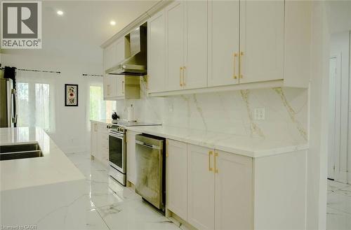 Kitchen featuring white cabinetry, gold-tone hardware, stainless steel appliances, and a countertop with integrated sink - 107 6Th Line Line, Haldimand, ON - Indoor Photo Showing Kitchen With Double Sink