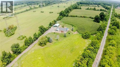 Expansive property featuring verdant fields, established trees, and a residential structure with an attached deck - 107 6Th Line Line, Haldimand, ON - Outdoor With View