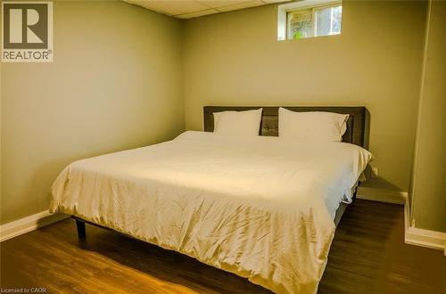 Wood-finish flooring with light wall tones and a window - 107 6Th Line Line, Haldimand, ON - Indoor Photo Showing Bedroom