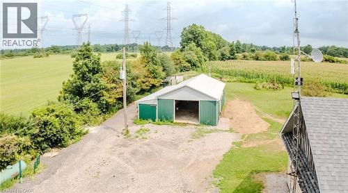 Gravel driveway leading to an expansive metal-sided barn with a white roof - 107 6Th Line Line, Haldimand, ON - Outdoor With View